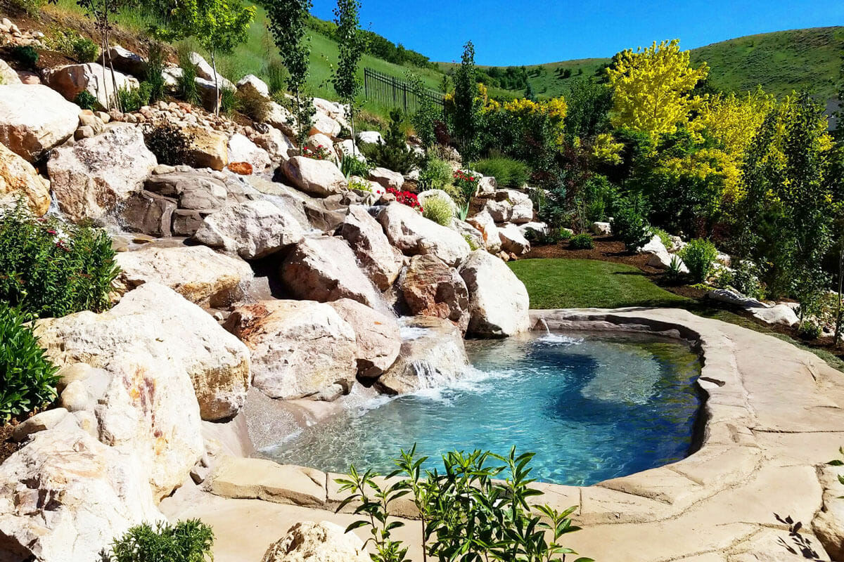 Custom rock pool waterfall in Utah backyard | Waterfall builders construction design | Stevenson Brothers Custom Pools