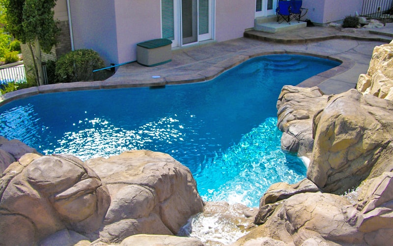 Custom Pool Builders install inground pool with rock waterfall