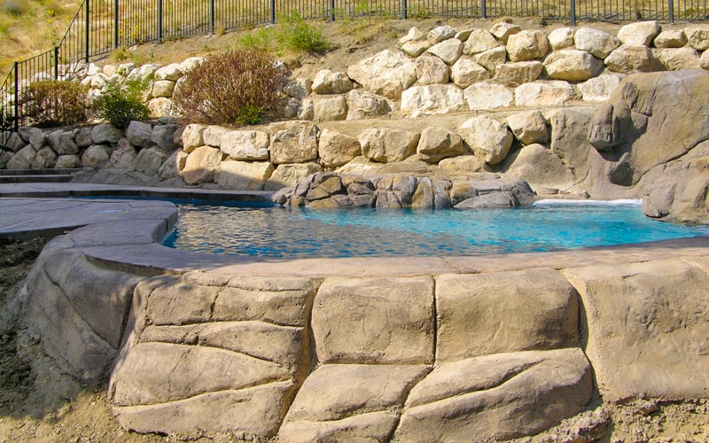 Outdoor Pool with Landscape Rock hardscaping | Pool Builders in Utah | SBI Waterfalls | Stevenson Brothers Custom Pools
