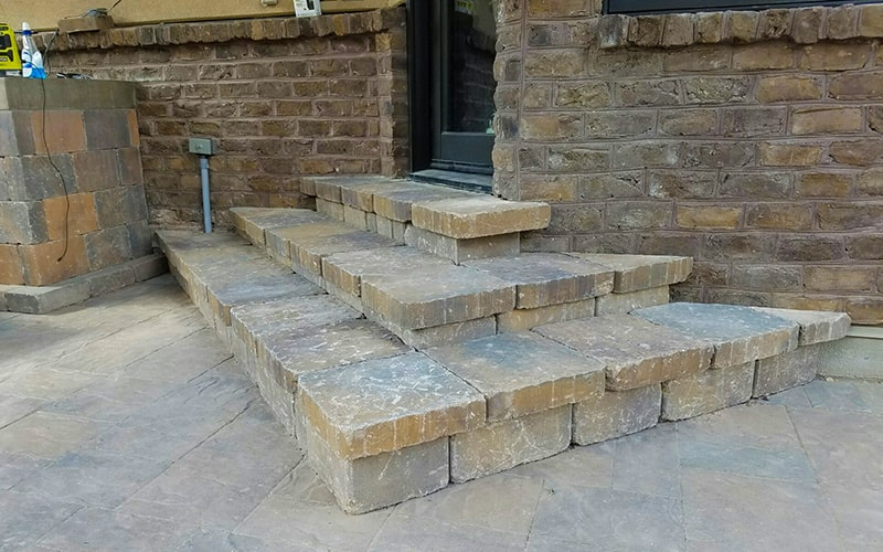 back door steps made from stones laid by patio pavers.