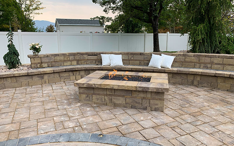Utah custom fire pit with pavers and paver seating with pillows