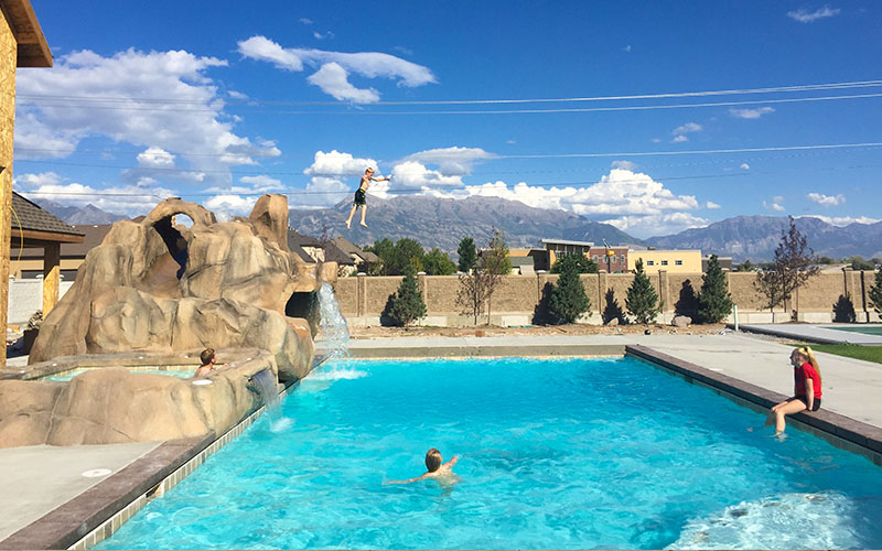 Utah Resort-Style Backyard Custom In-ground Swimming Pool with Rock Slide and Waterfall Builders in Salt Lake City, UT | Stevenson Brothers Custom Pools | SBI Waterfalls