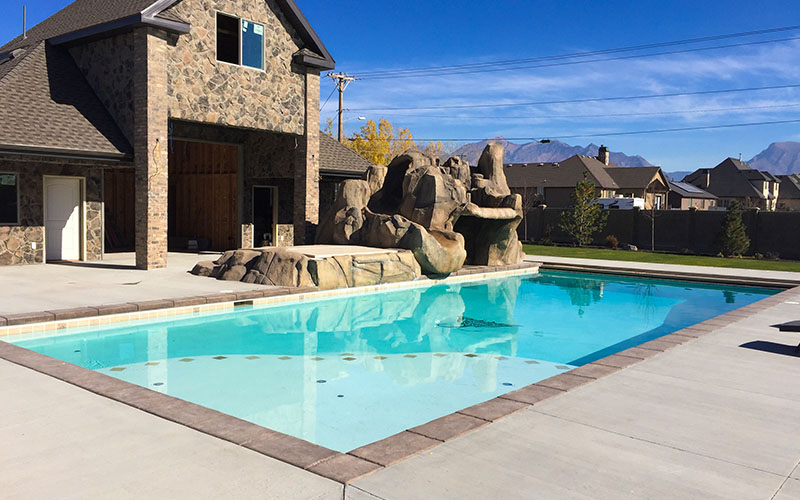 Geometric swimming pool with baja shelf & waterfall in Utah | Stevenson Brothers Custom Pools | SBI Waterfalls
