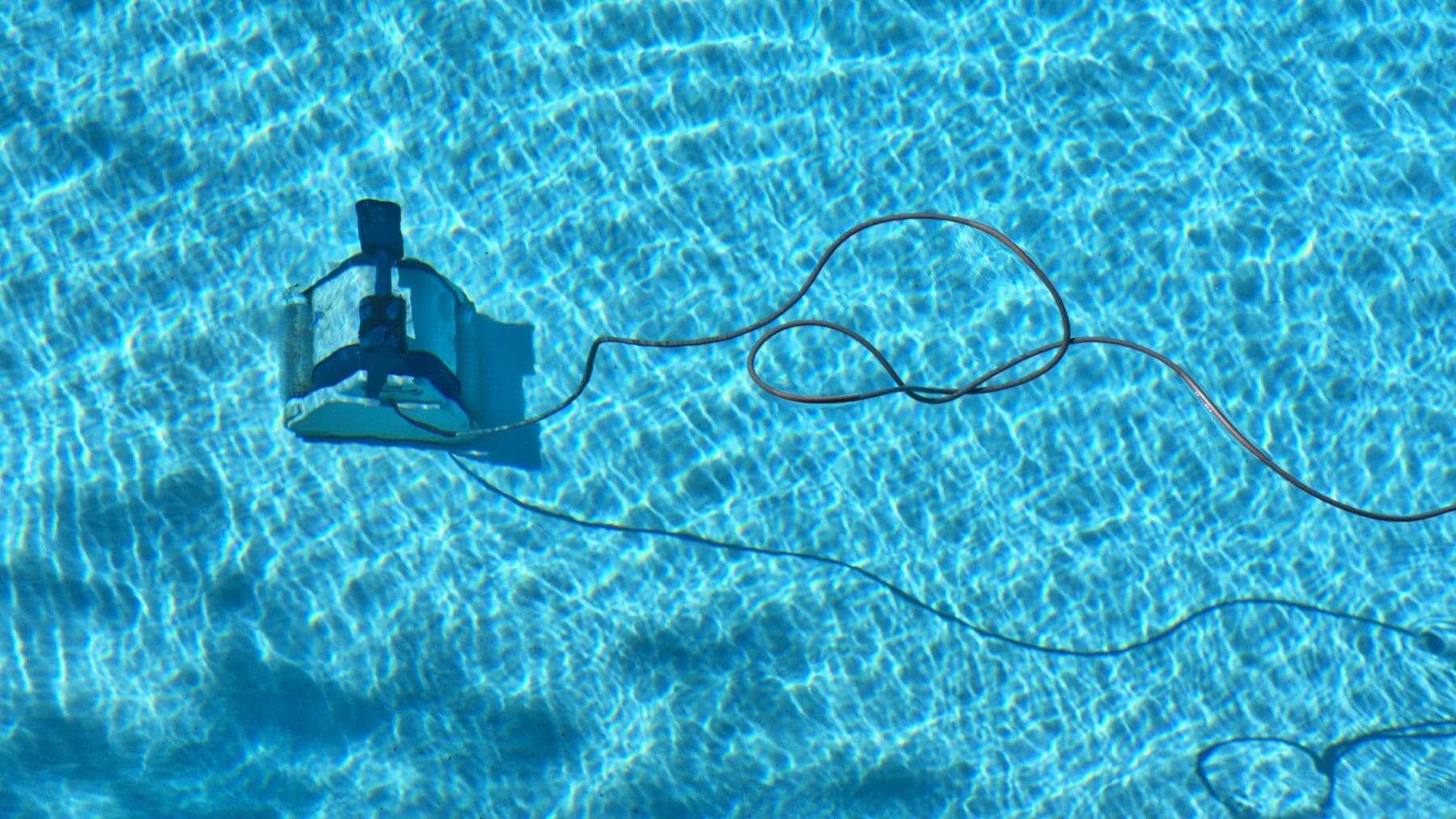 A pool vacuum at the bottom of a pool cleaning.