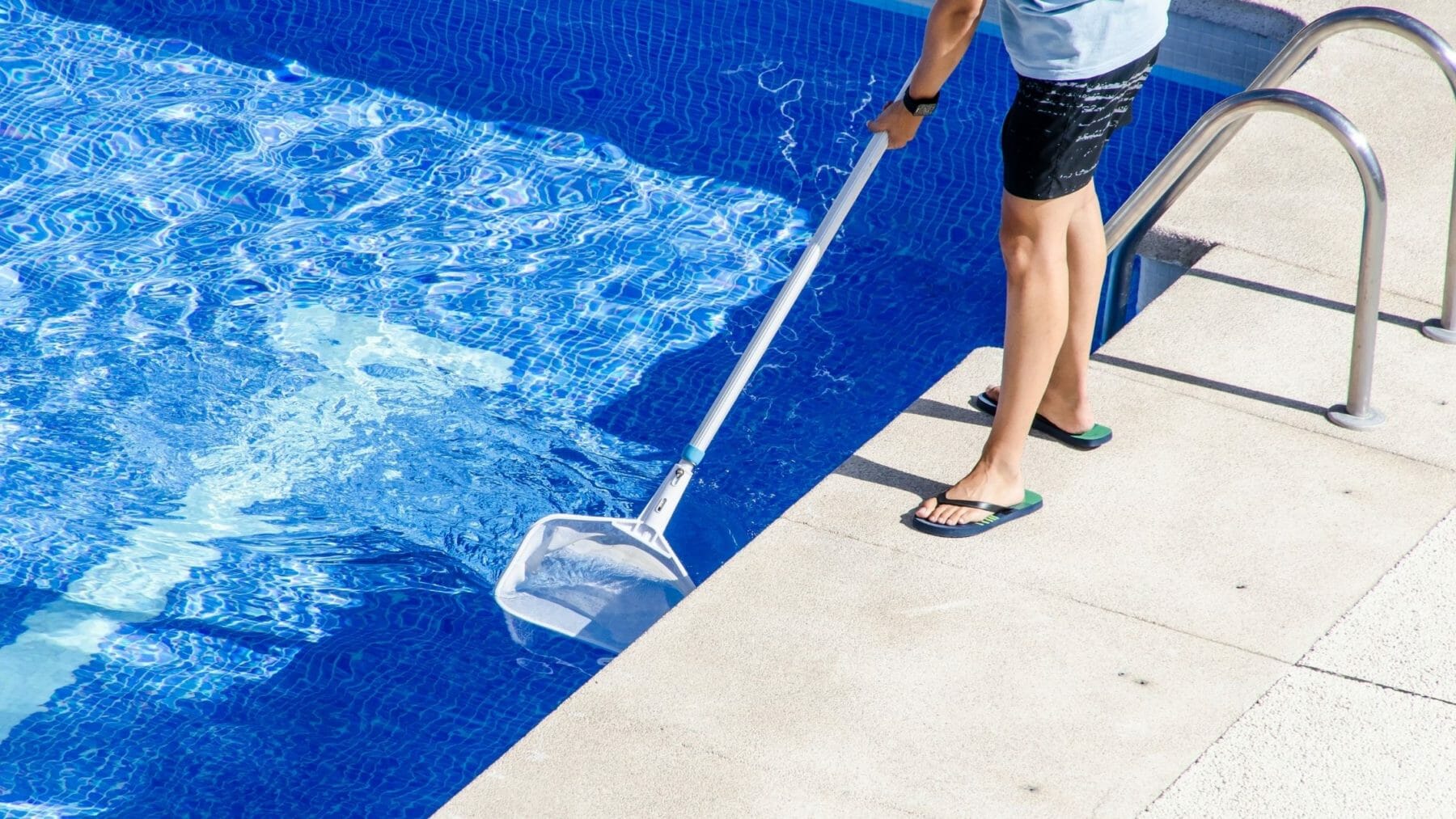 A pool owner cleaning his pool