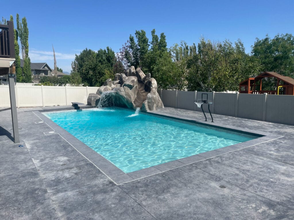 Custom concrete patio pavers - custom swimming pool - custom rock waterfall with slide