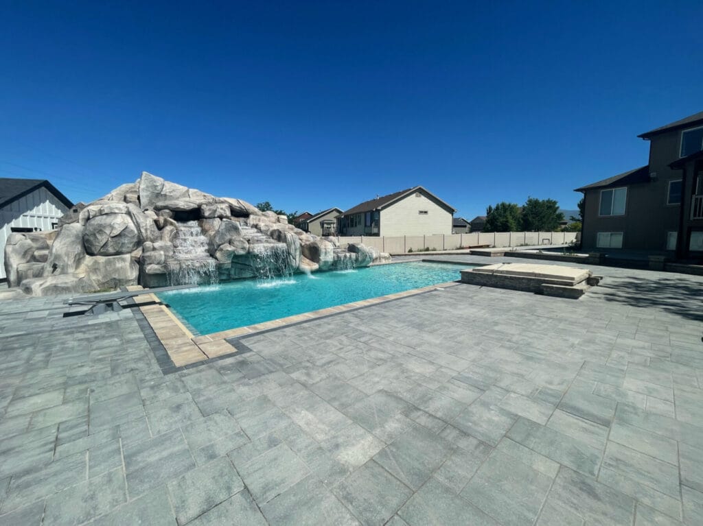 Custom swimming pool construction project with artificial rock waterfall & slide in Salt Lake City, Utah completed by Stevenson Brothers Custom Pools
