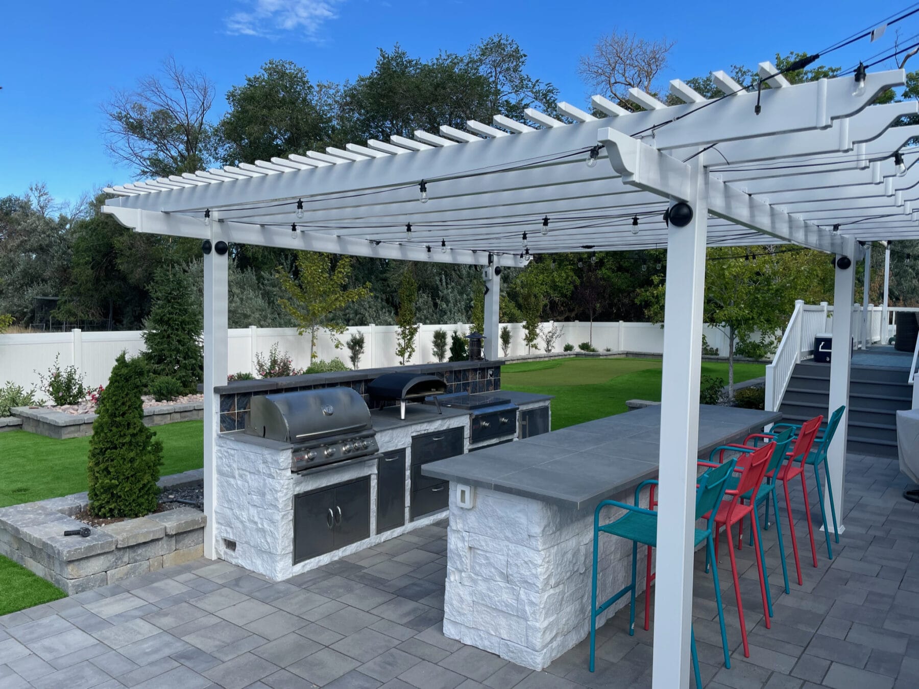 Custom outdoor kitchen, bar, pergola, and patio landscaping in Salt Lake City, Utah backyard - Stevenson Brothers Custom Pools